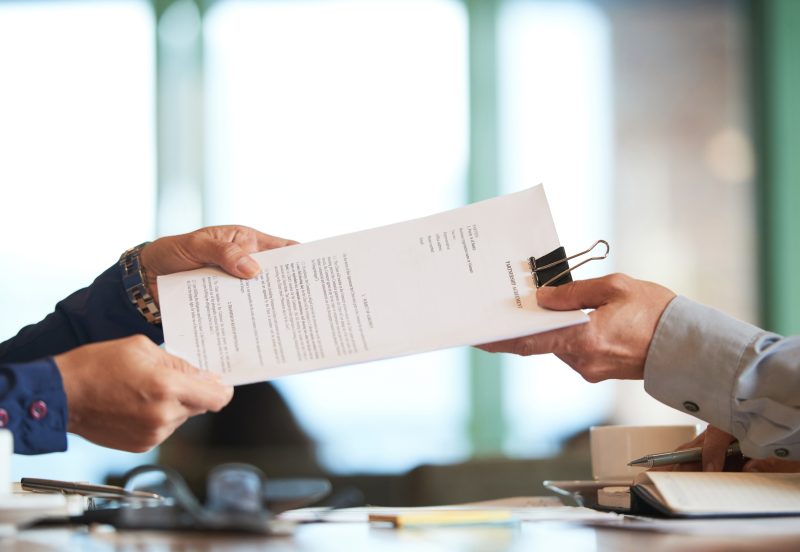 Business person giving partnership agreement to coworker